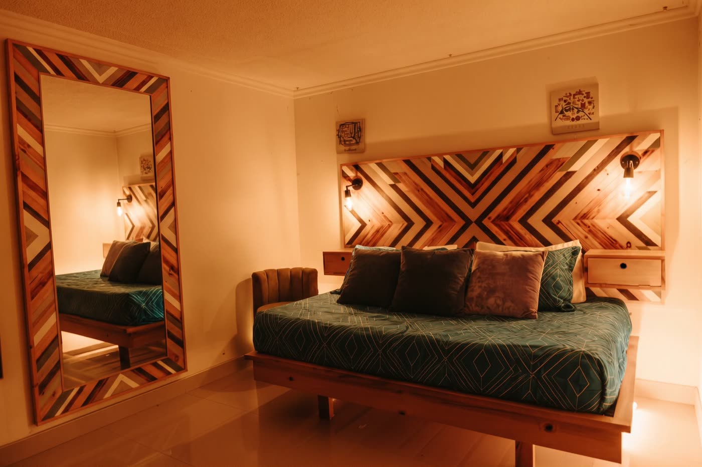 Room Ámbar con luz cálida, cabecero de madera en espiga y espejo grande